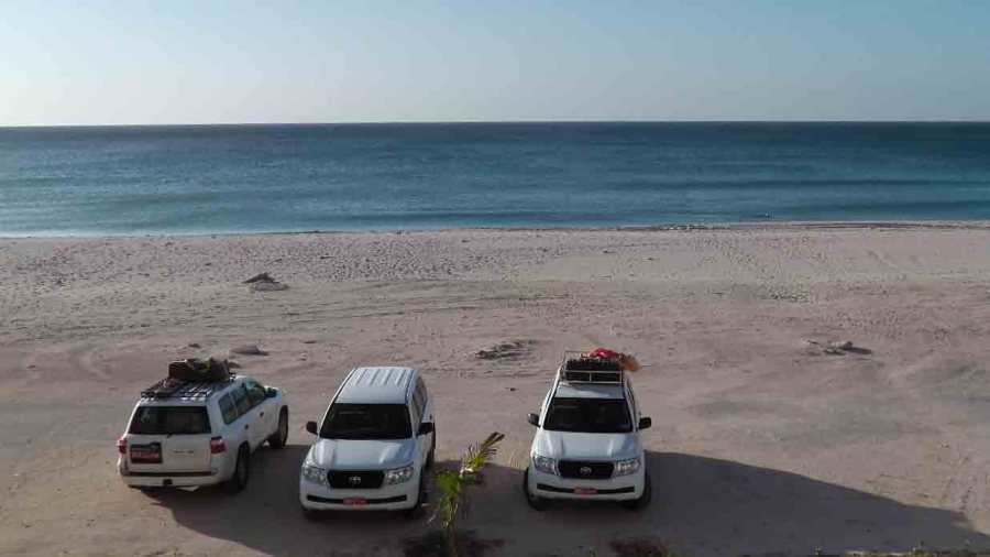 Blick aus unserem Hotelzimmer auf den Strand, im Vordergrund die Expeditionsfahrzeuge